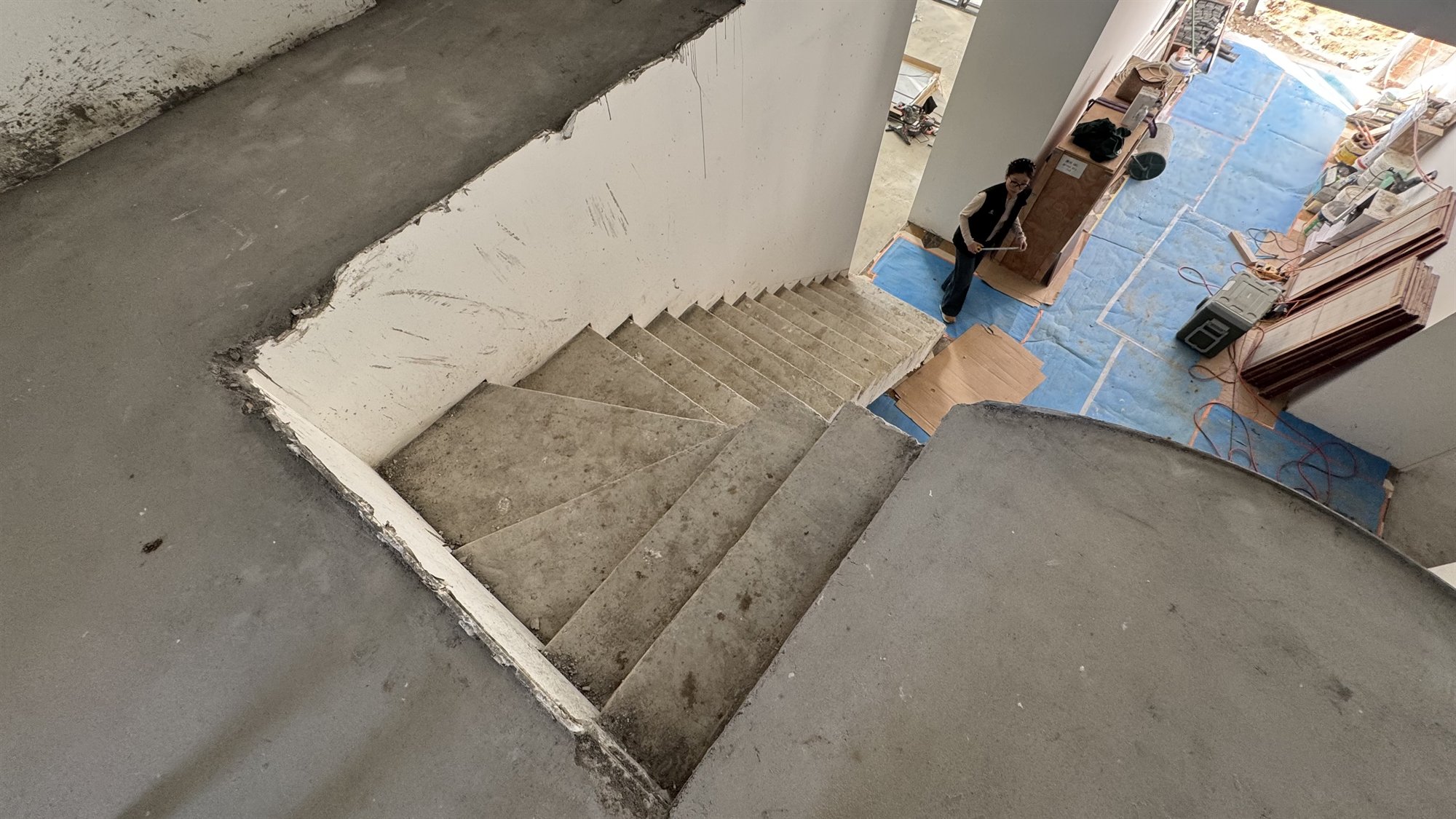 A concrete winder staircase seen from above in a Sydney home under construction, with the treads turning around the corner