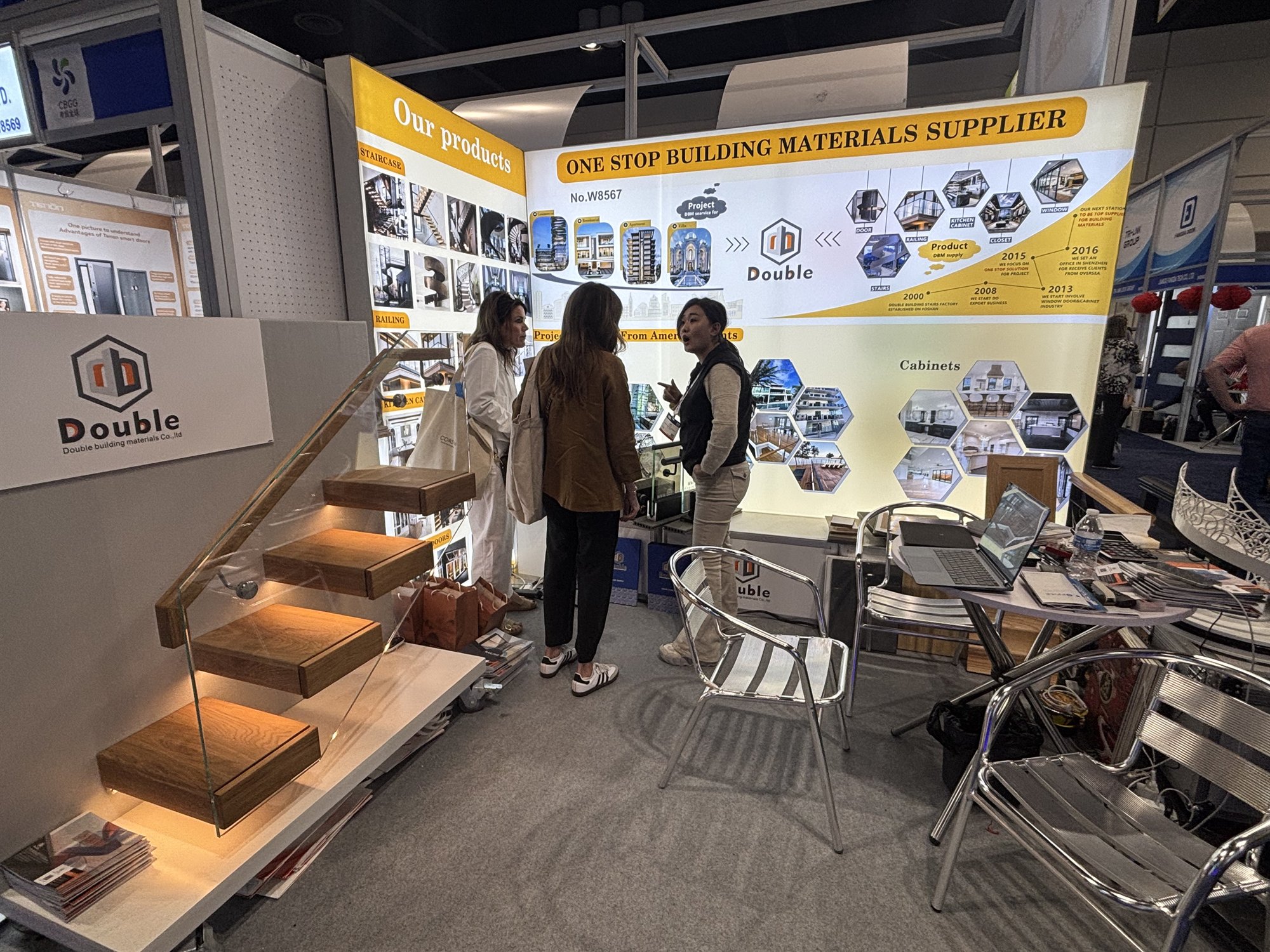 Two visitors looking at the floating-staircase display model on the Double Building Materials stand at the IBS 2026 builders show
